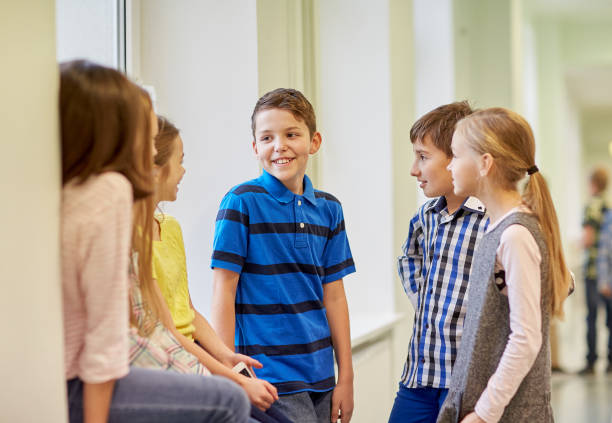 istock group of smiling school kids talking in corridor 857768794