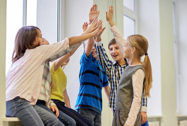 istock group of smiling school kids making high five 857769106
