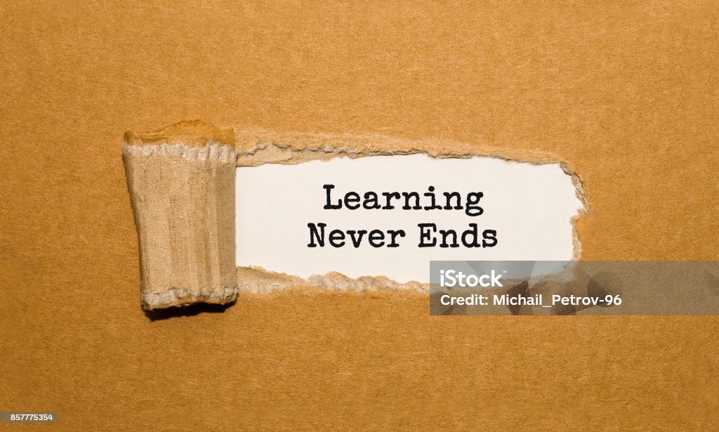 The text Learning Never Ends appearing behind torn brown paper The End Stock Photo