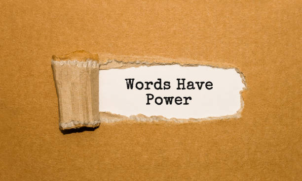 The text Words Have Power appearing behind torn brown paper stock photo