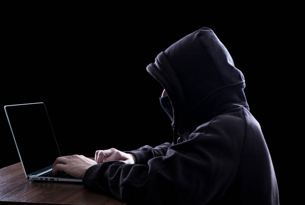 istock Hacker in hoodie working on laptop in the dark hacking secured network 857778194