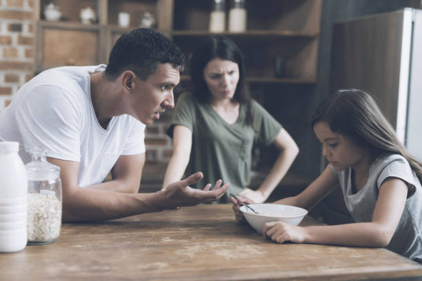 istock The girl looks sad at her plate with breakfast, while her parents scold her 857779106