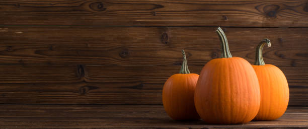 istock Pumpkins on wooden background 857782104