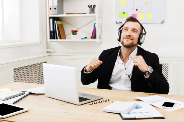 istock Young relaxed businessman listen music in modern white office 857782122