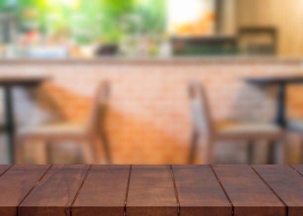 istock Empty wooden top table and blurred coffee shop background 857789228