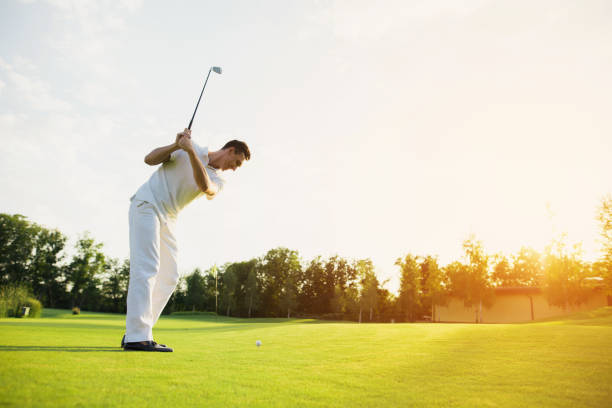 istock A man in a white suit plays golf. He took the stick and was preparing to strike 857789788