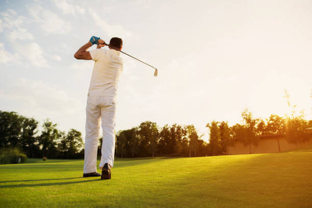 istock View from the back. The man made an excellent impact, while playing golf 857790338
