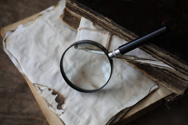 istock Old books on a wooden table and magnifier 857793116