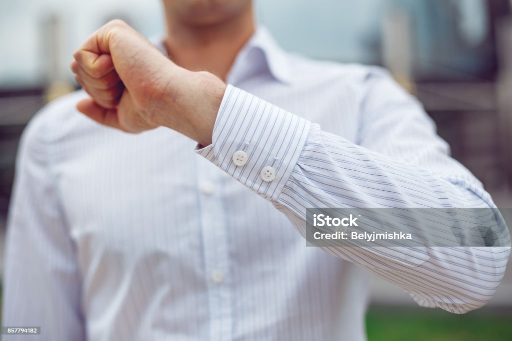 Close up of a businessman in a white shirt and shows the sleeve Close up of a businessman in a white shirt and shows the sleeve of the shirt and the hand. Adult Stock Photo