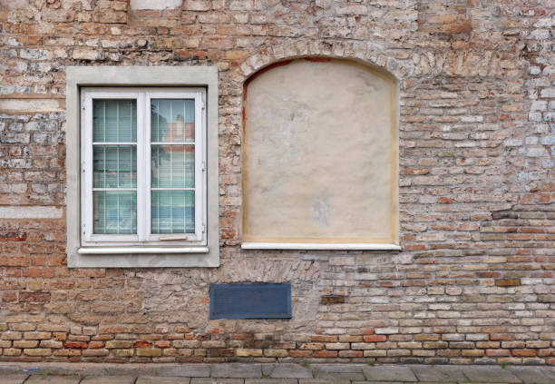 Blind curved basement windows  in the old aged red bricks house. Outdoor background