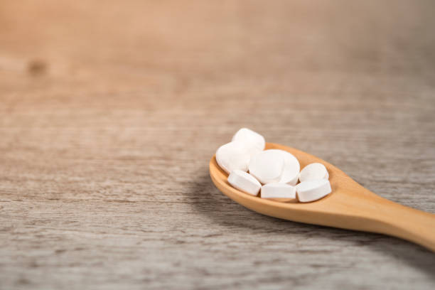 istock Medicine pills on wooden spoon. 857795426