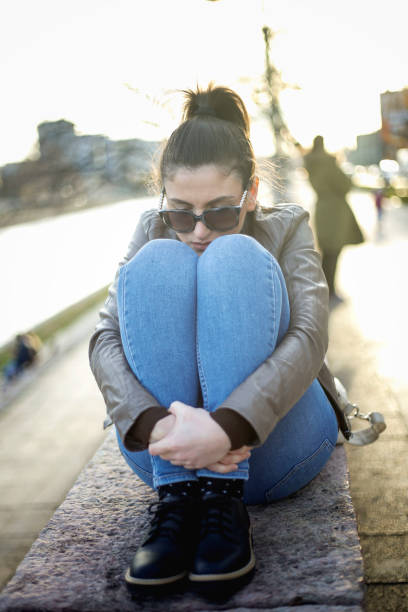istock Beautiful young girl sitting sadly 857797936