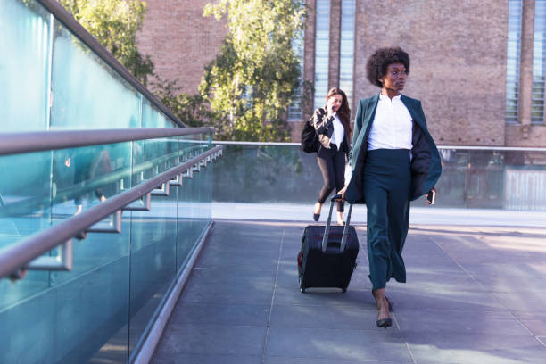 istock Woman walking down a footbridge with another behind her on a phone 857798158