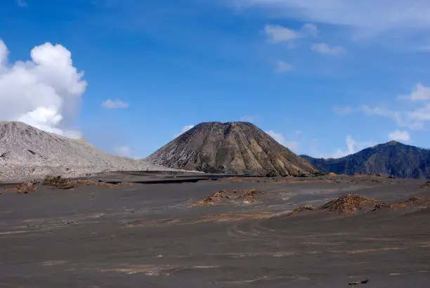 Brown volcanic sand at the foot of  mount Batok next to the active volcano mount Bromo early in the morning at the Tengger Semeru National Park in East Java, Indonesia.