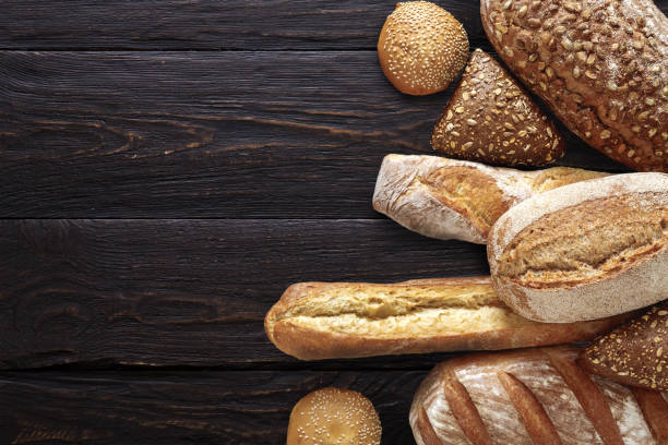 хлебобулочные фон, ассортимент хлеба на черном - french loaf стоковые фото и изображения