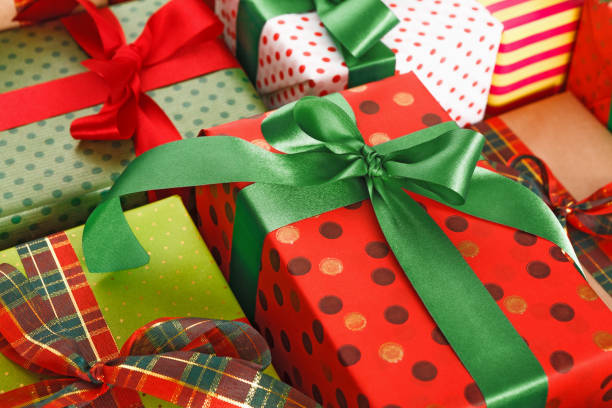 istock Stylish creative presents in colored paper decorated with red, green satin ribbon bows 857805426