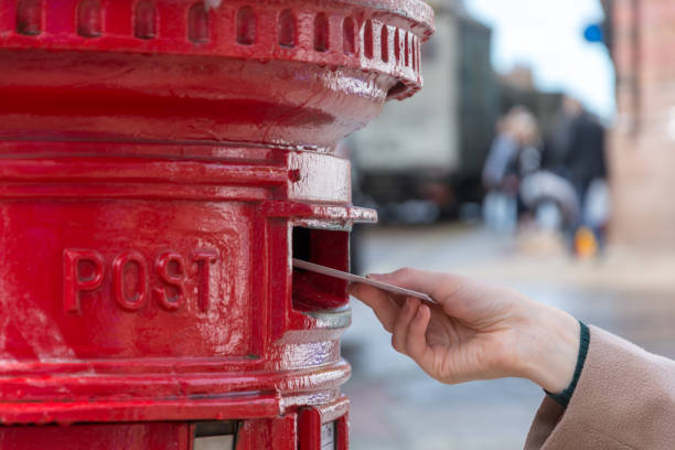 istock Throwing a letter in a red British post box from the side 857805974