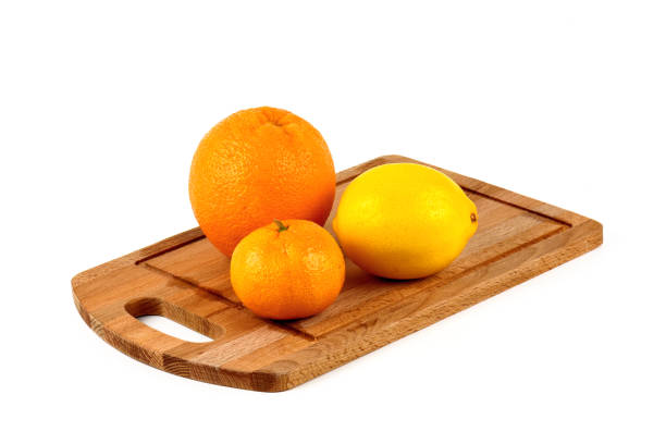 istock Mandarin, lemon and orange on a wooden cutting board on a white background. 857813870