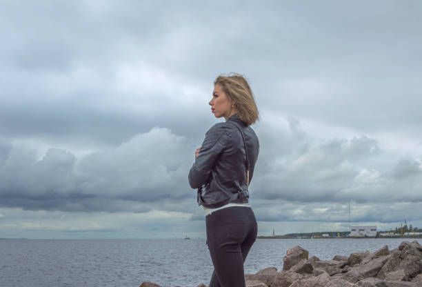 istock on a cloudy day on the stone seashore, is a beautiful girl 857814148