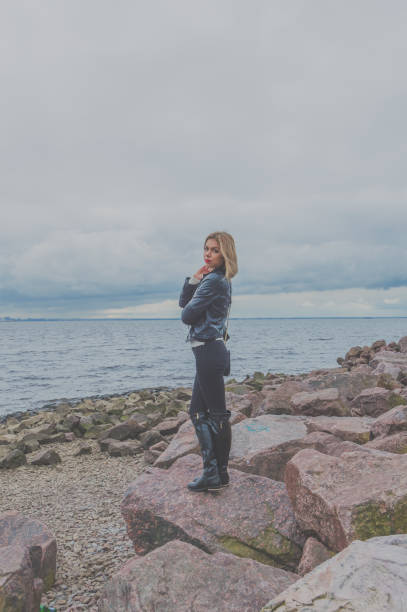 istock stone on the seashore is an attractive girl 857816670