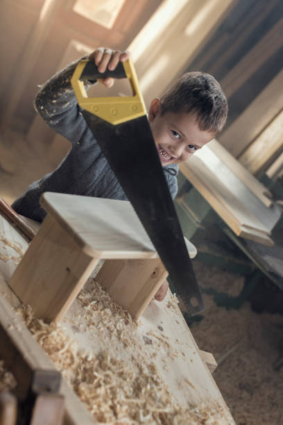 istock Young Boy Playing in the Carpentry Shop 857817808