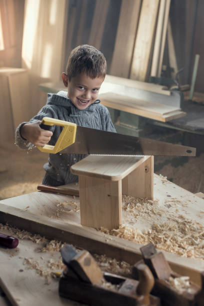 istock Young Boy Playing in the Carpentry Shop 857817854