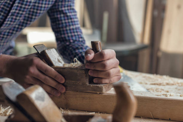 istock Close-up hands of Hipster Carpenter Milling a Plank 857817900