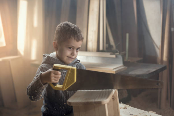 istock Young Boy Playing in the Carpentry Shop 857817902