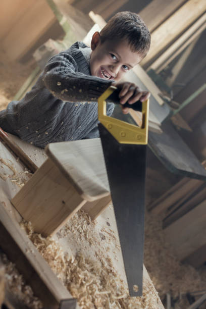 istock Young Boy Playing in the Carpentry Shop 857817904