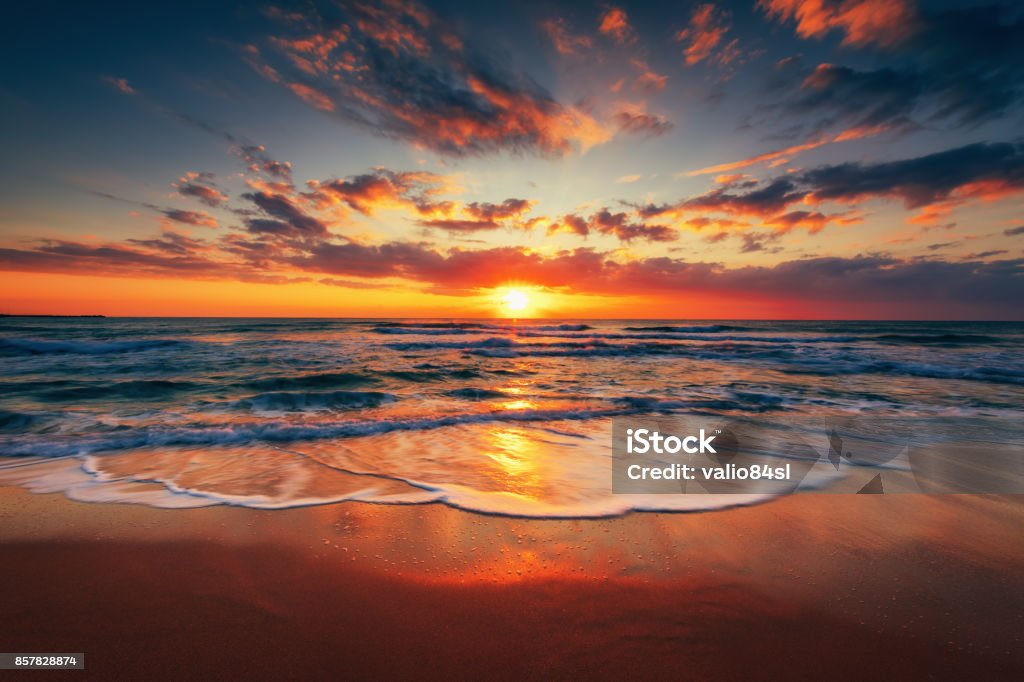 Amanecer en la playa y cloudscape hermoso sobre el mar - Foto de stock de Puesta de sol libre de derechos