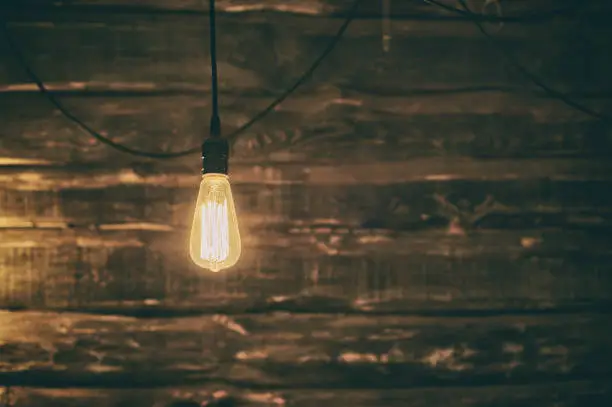 Photo of Light Edison bulb on dark wooden background