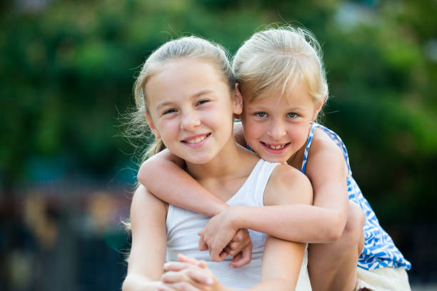 istock Two smiling little girls embracing 857832218