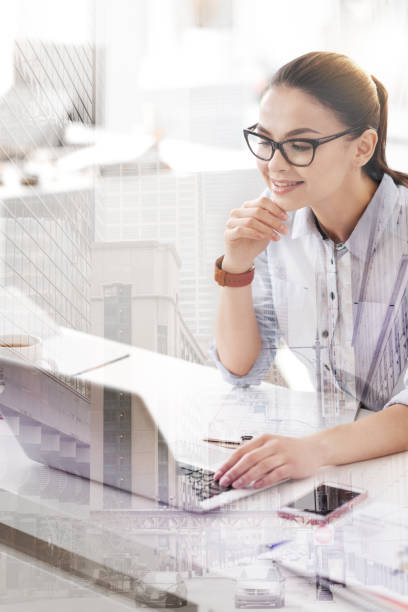 istock Cheerful woman using her laptop in the office 857832994