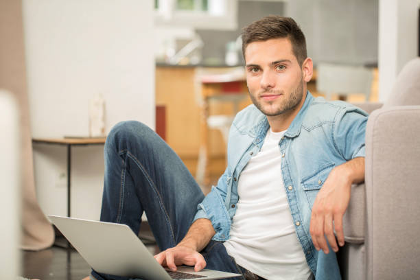 istock Upper view of young man using laptop computer at home 857833746