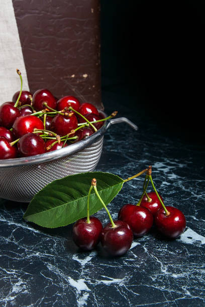 Several red sweet cherries and big green leaf