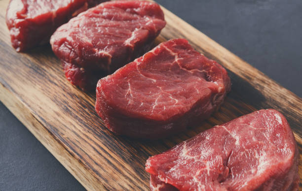rohes rindfleisch filet mignon steaks auf holzbrett auf grauem hintergrund - steak filet mignon gourmet fillet stock-fotos und bilder
