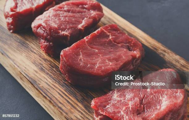 Raw Beef Filet Mignon Steaks On Wooden Board At Gray Background Stock Photo - Download Image Now