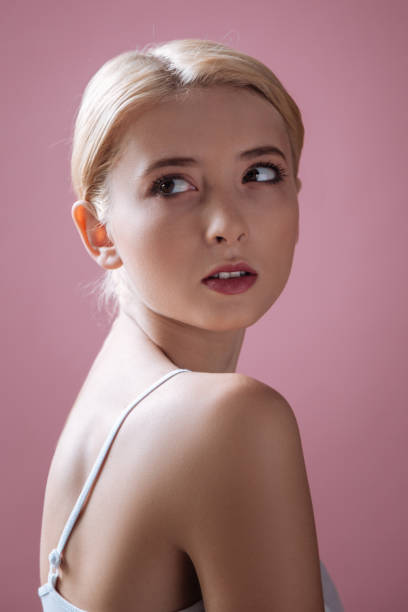 portret delikatnej dziewczyny, która otwiera usta - vertical studio shot indoors pink zdjęcia i obrazy z banku zdjęć