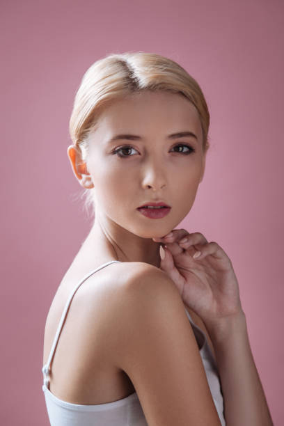 młody model pozujący prosto do kamery - vertical studio shot indoors pink zdjęcia i obrazy z banku zdjęć