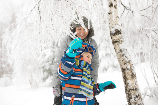 istock Mother and son enjoying in snowy winter forest 857852344