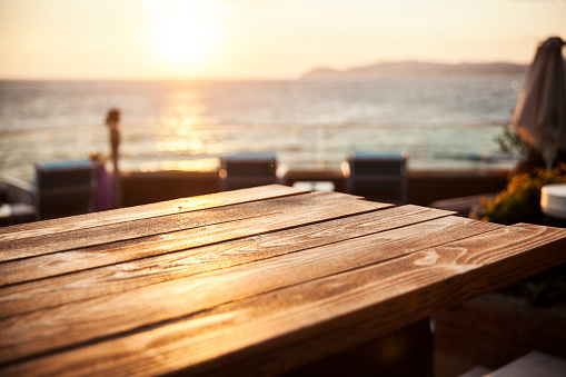 wooden table against sunset on sea, close up