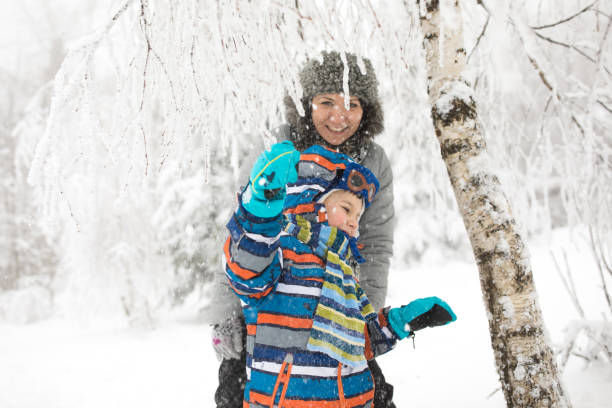 istock Mother and son enjoying in snowy winter forest 857856642