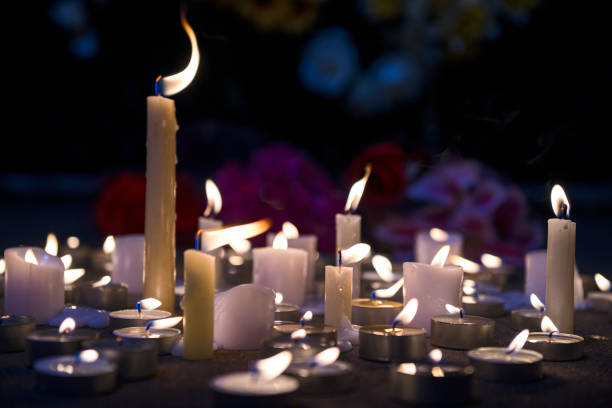 istock A makeshift memorial vigil with various size candles and flowers at night 857856678