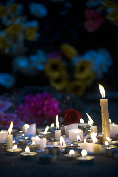 istock A makeshift memorial vigil with various size candles and flowers at night 857856988