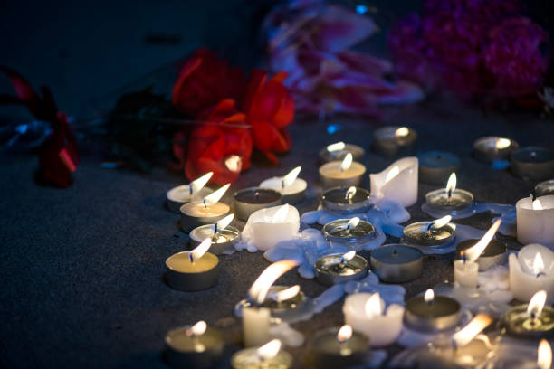 istock Candles and flowers at a makeshift memorial vigil at night 857857086