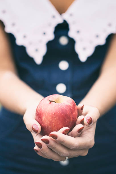 istock Hands of a girl holding a red apple 857865298
