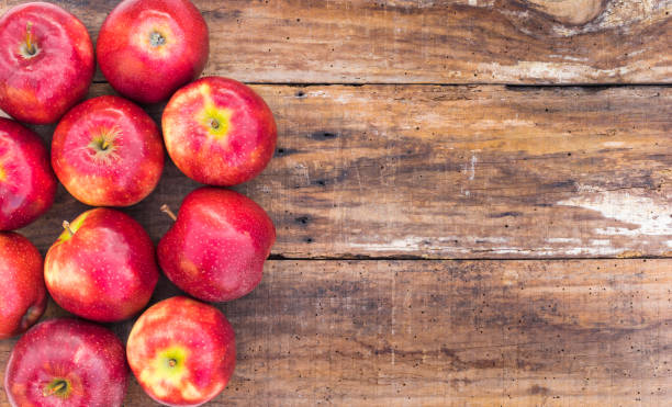istock Fresh red apples on wooden background 857865968