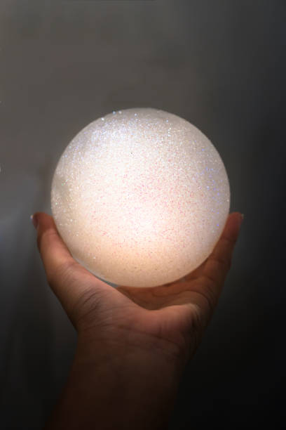 istock Hand holding a glowing glitter ball 857873938