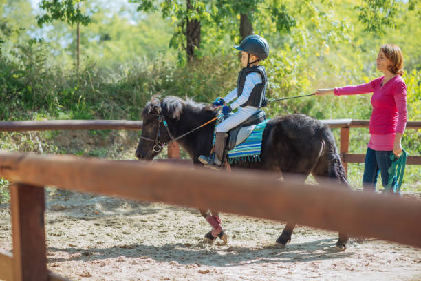 istock Personal trainer in horseback riding school for kids 857895004