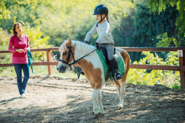 travail d’équipe avec les enfants et les chevaux à l’école d’équitation - pony photos et images de collection